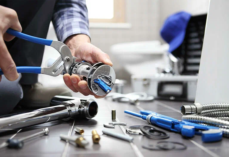 Technician repairing a plumbing fixture with professional tools in Panama City
