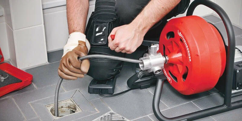 Plumber using a drain-cleaning machine in Panama City