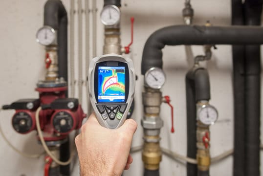 Plumber using a thermal imaging camera to inspect pipes in Panama City