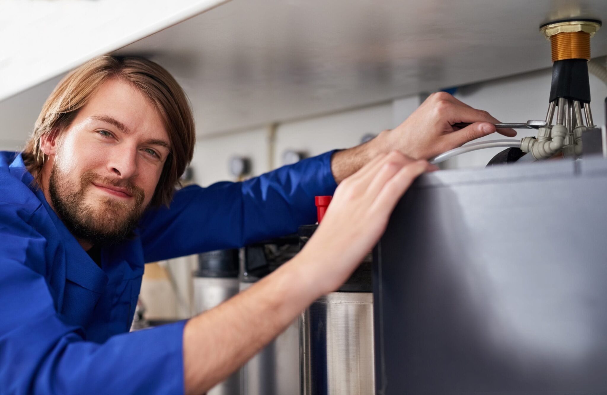 Technician servicing a residential water heater tank in Panama City