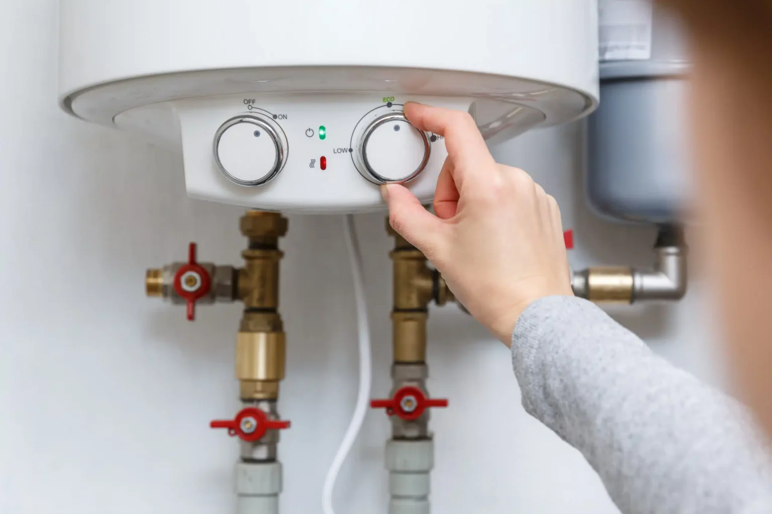 Homeowner adjusting the temperature controls on a water heater in Panama City